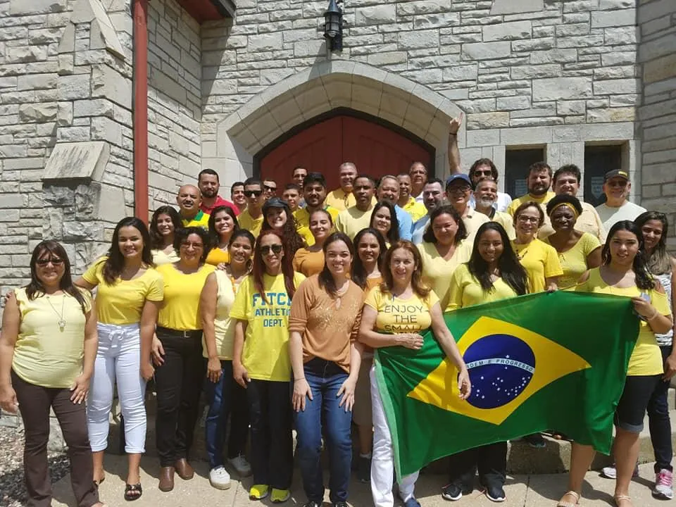 Grupo de estudantes da linveup english na frente de um museu com cores de brasil
